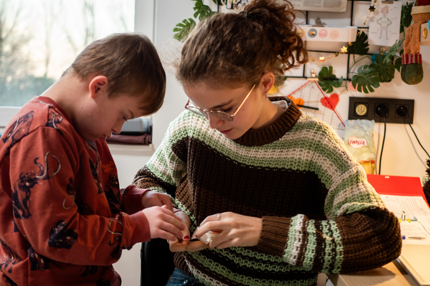 Lilith helpt haar broer met een speelgoedje